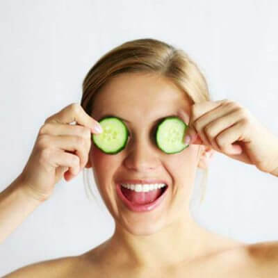 A woman with slices of cucumber placed on her eyes, as a way of getting rid of saggy skin under the lower eyelids.